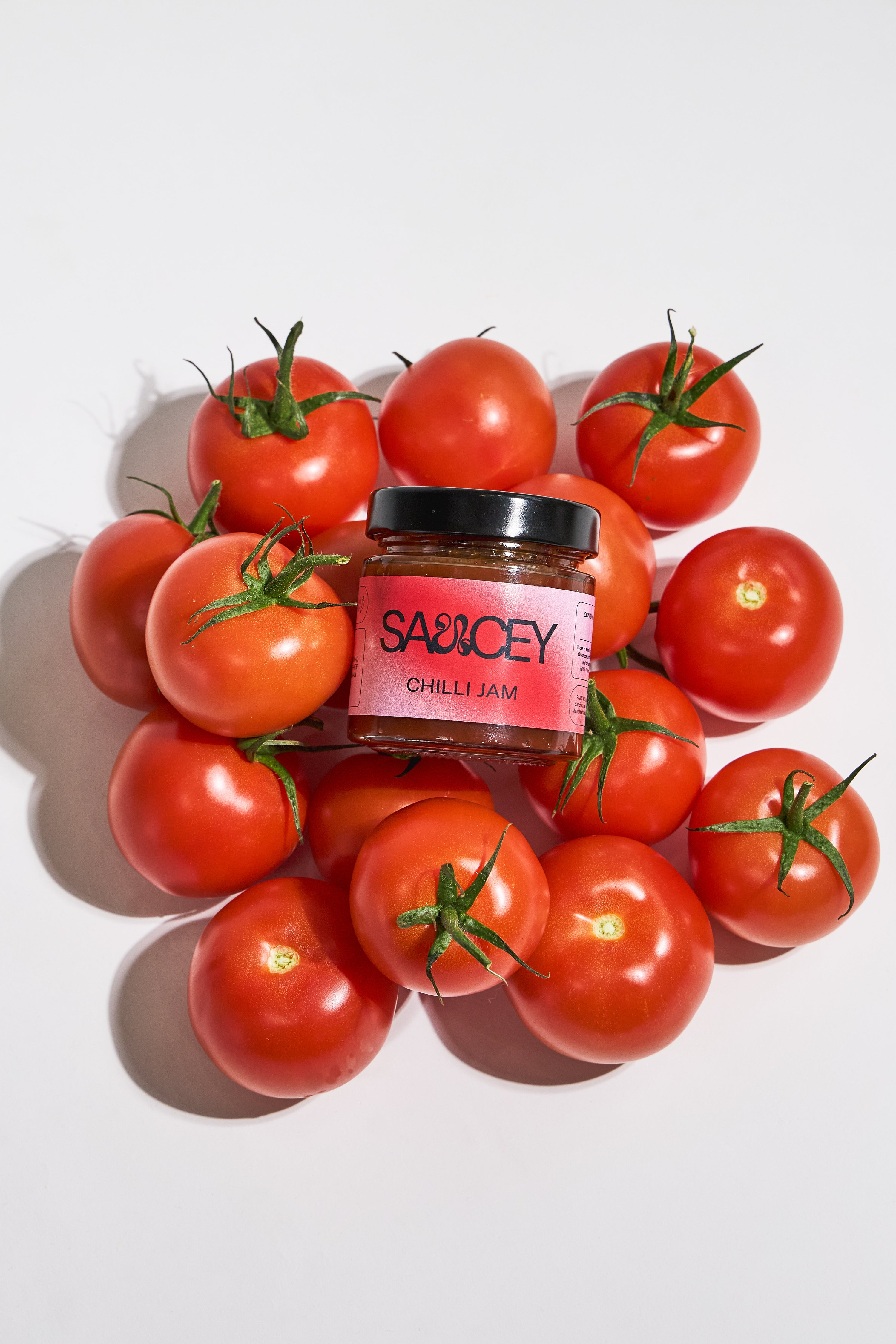 A bottle of SAUCEY red sweet chilli jam on the tomatoes